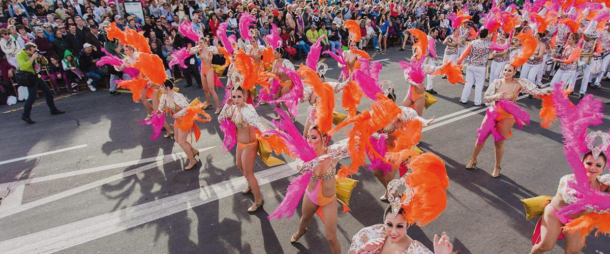 People in brightly coloured costumes performing in a carnival in Tenerife